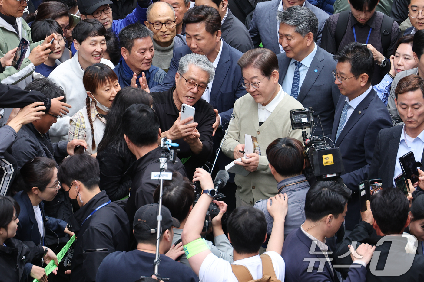 (영동=뉴스1) 안은나 기자 = 이재명 더불어민주당 대통령 후보가 골목골목 경청투어 이틀차인 6일 오후 충북 영동군 영동중앙시장을 찾아 시민과 셀카를 찍고 있다. 2025.5.6/ …