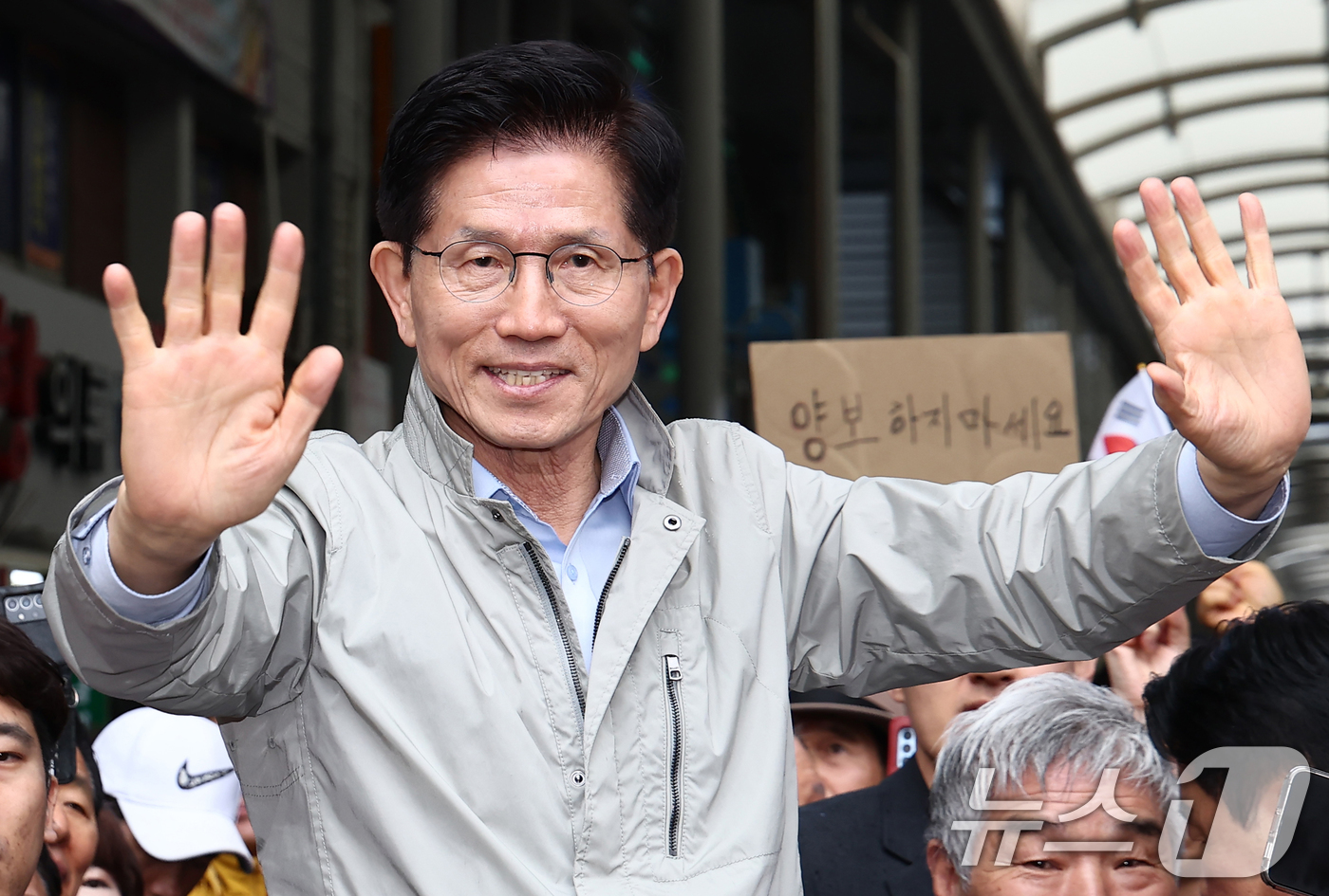 (포항=뉴스1) 김민지 기자 = 김문수 국민의힘 대통령 후보가 6일 경북 포항시 죽도시장에서 시민들을 향해 인사하고 있다.뒷편에는 한 지지자가 '양보 하지 마세요'라고 적힌 종이를 …