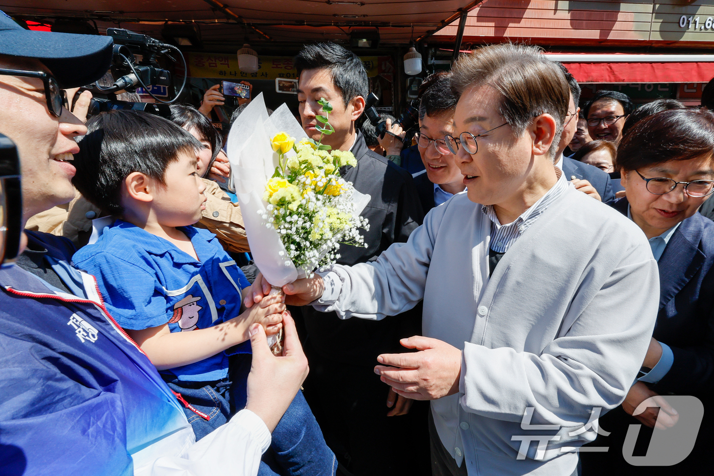 (진안=뉴스1) 안은나 기자 = 이재명 더불어민주당 대통령 후보가 2차 골목골목 경청투어 마지막 날인 7일 오전 전북 진안군 진무로를 찾아 어린이에게 꽃다발을 선물받고 있다. 20 …