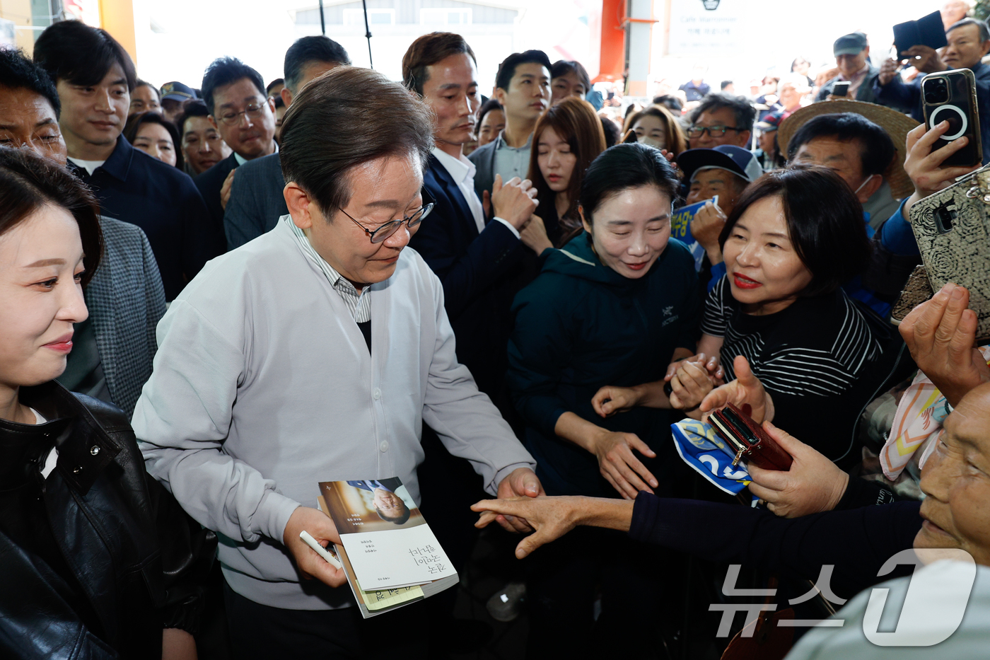 (임실=뉴스1) 안은나 기자 = 이재명 더불어민주당 대통령 후보가 2차 골목골목 경청투어 마지막 날인 7일 오전 전북 임실군 임실시장을 찾아 인사하고 있다. 2025.5.7/뉴스1 …