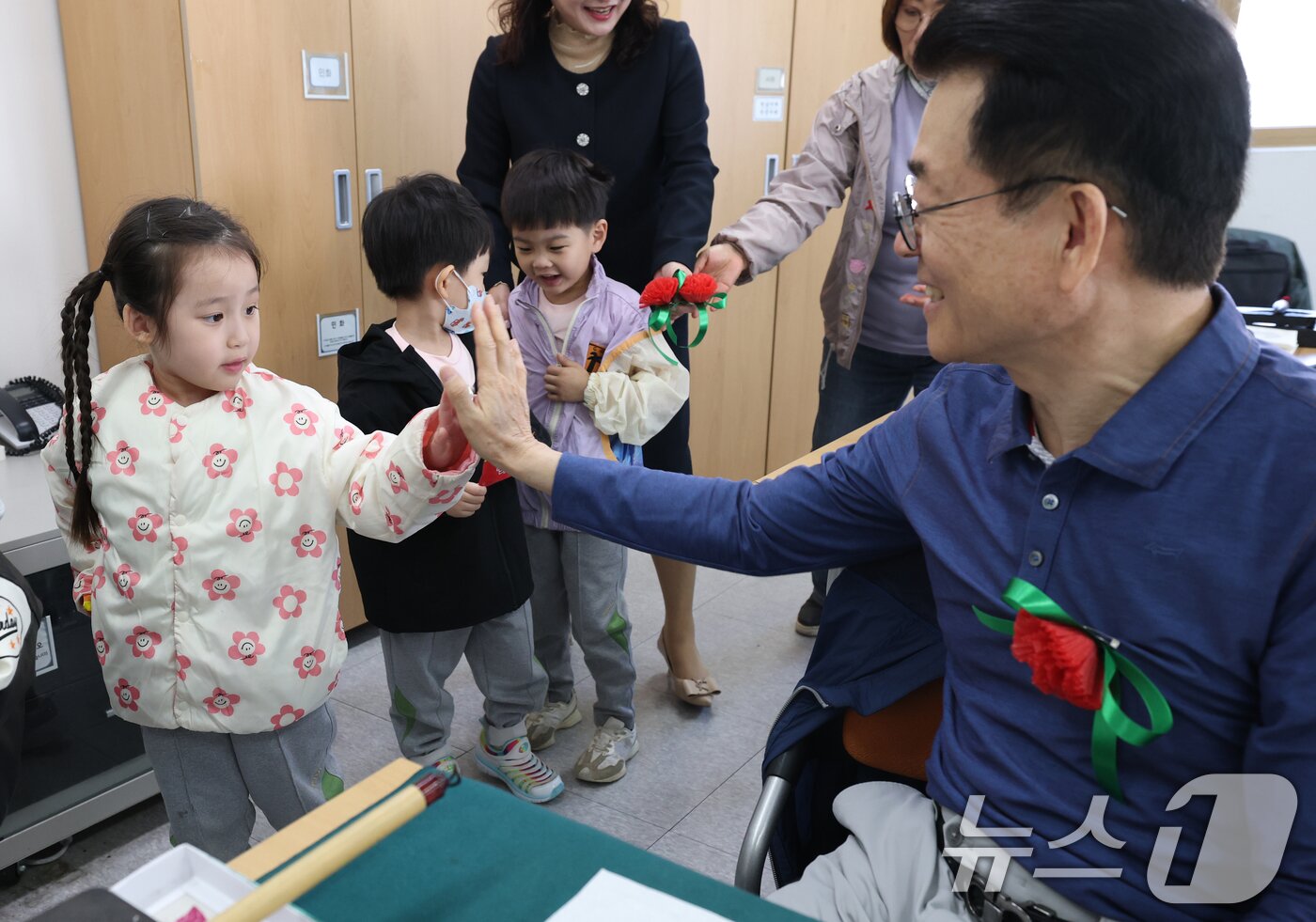 본문 이미지 - 어버이날을 하루 앞둔 7일 오전 경기 수원시 팔달구 팔달노인복지관에서 관내 어린이집 아이들이 어르신들에게 카네이션을 달아드린 뒤 하이파이브을 하고 있다. 2025.5.7/뉴스1 ⓒ News1 김영운 기자