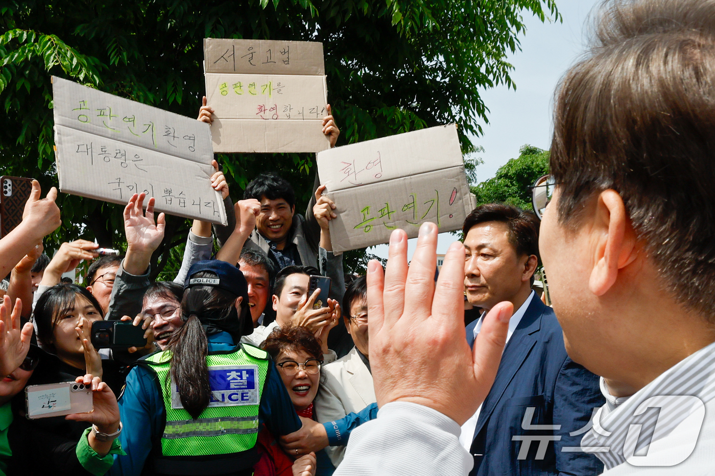 (전주=뉴스1) 안은나 기자 = 이재명 더불어민주당 대통령 후보가 2차 골목골목 경청투어 마지막 날인 7일 오후 전북 전주시 풍남문 앞에서 '공판연기 환영' 종이를 든 지지자들에게 …