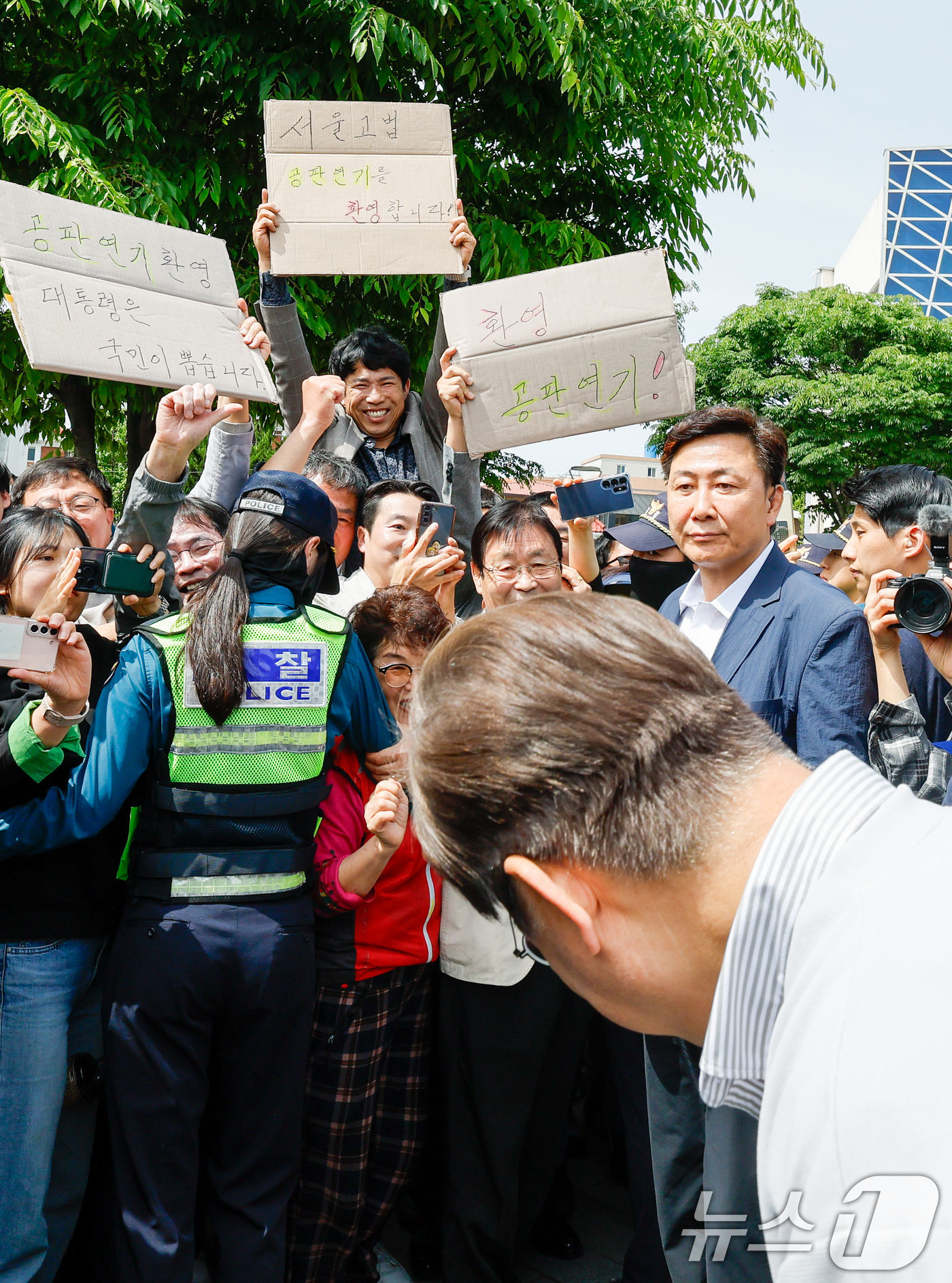 (전주=뉴스1) 안은나 기자 = 이재명 더불어민주당 대통령 후보가 2차 골목골목 경청투어 마지막 날인 7일 오후 전북 전주시 풍남문 앞에서 '공판연기 환영' 종이를 든 지지자들에게 …