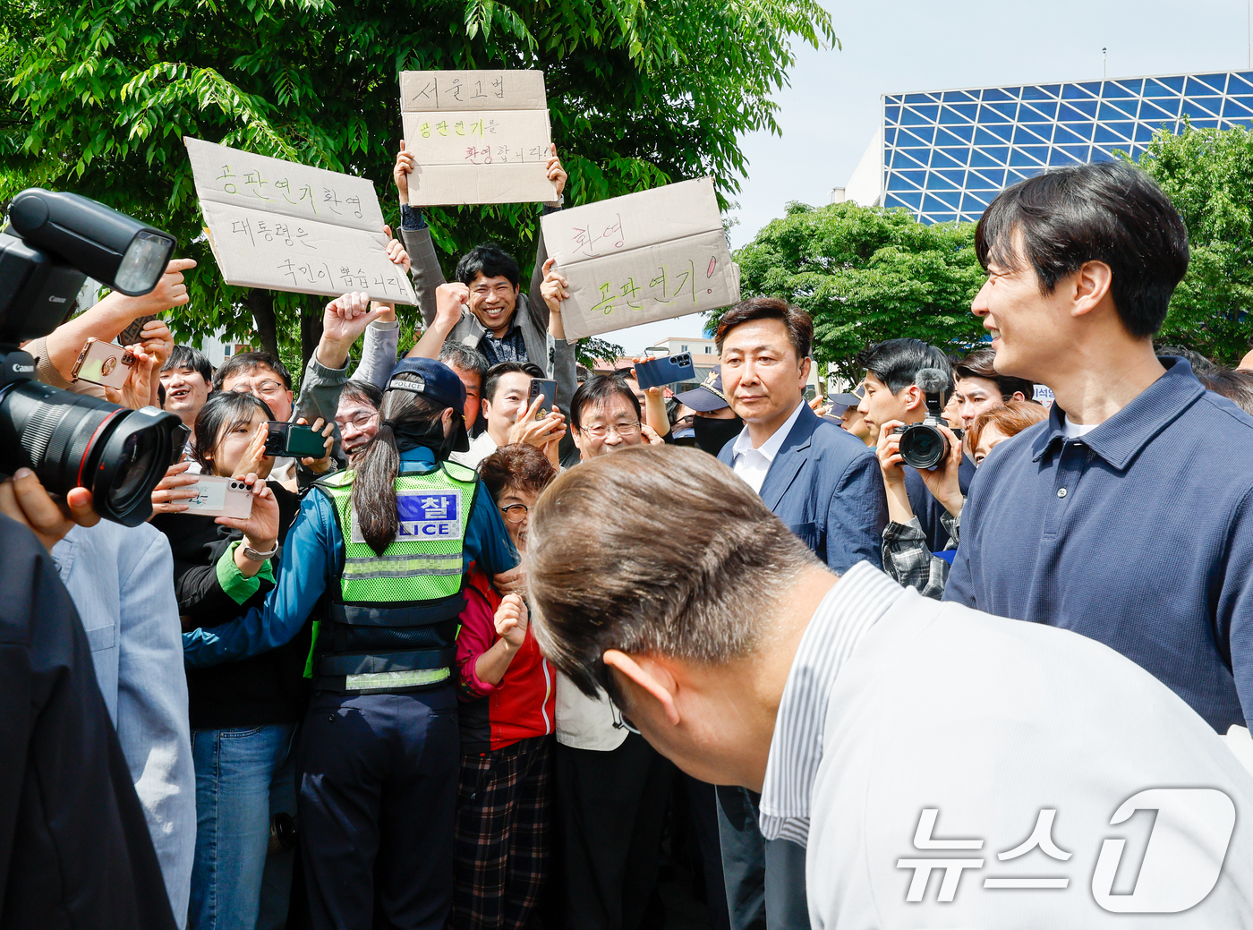 (전주=뉴스1) 안은나 기자 = 이재명 더불어민주당 대통령 후보가 2차 골목골목 경청투어 마지막 날인 7일 오후 전북 전주시 풍남문 앞에서 '공판연기 환영' 종이를 든 지지자들에게 …