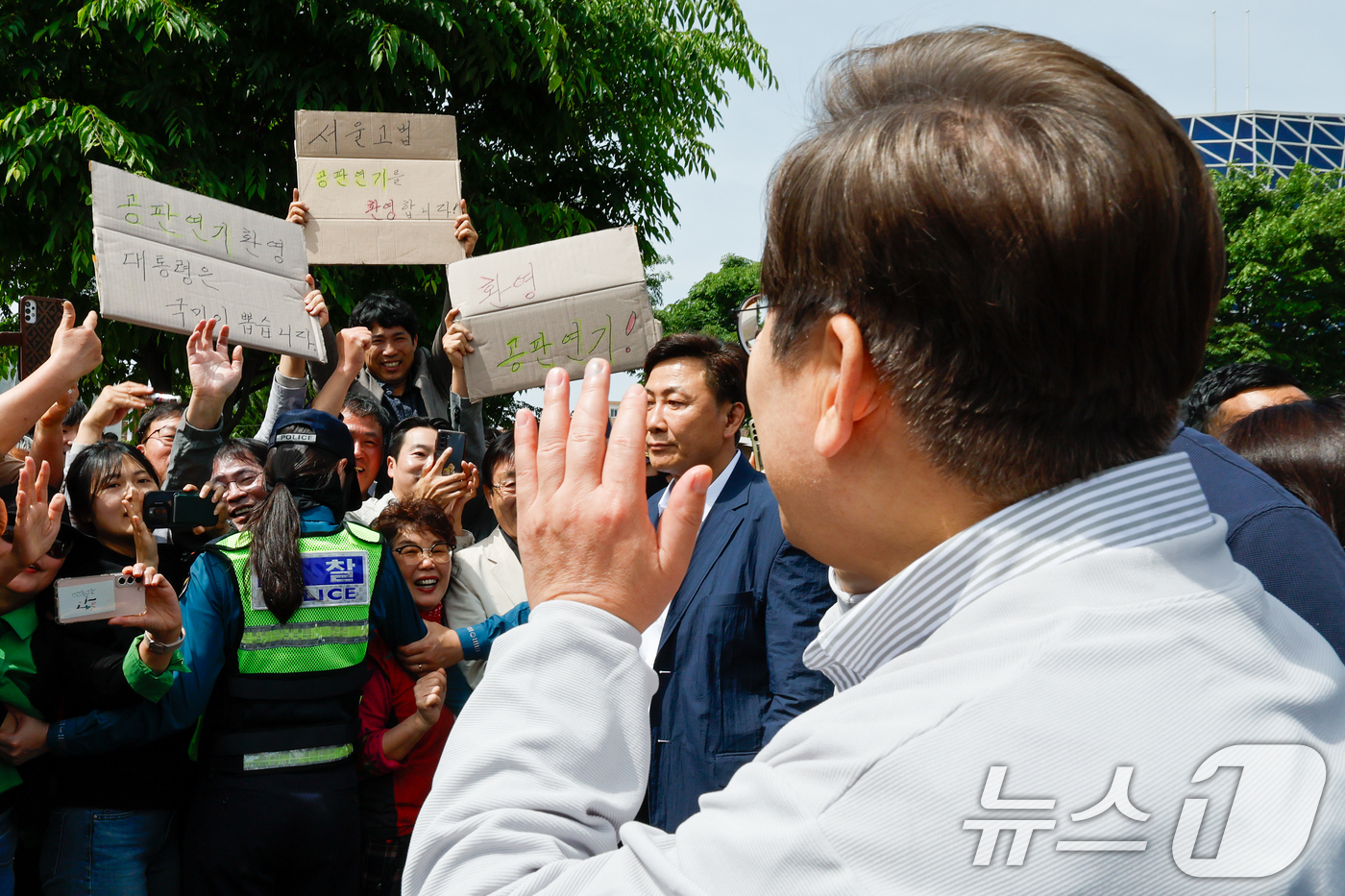 (전주=뉴스1) 안은나 기자 = 이재명 더불어민주당 대통령 후보가 2차 골목골목 경청투어 마지막 날인 7일 오후 전북 전주시 풍남문 앞에서 '공판연기 환영' 종이를 든 지지자들에게 …