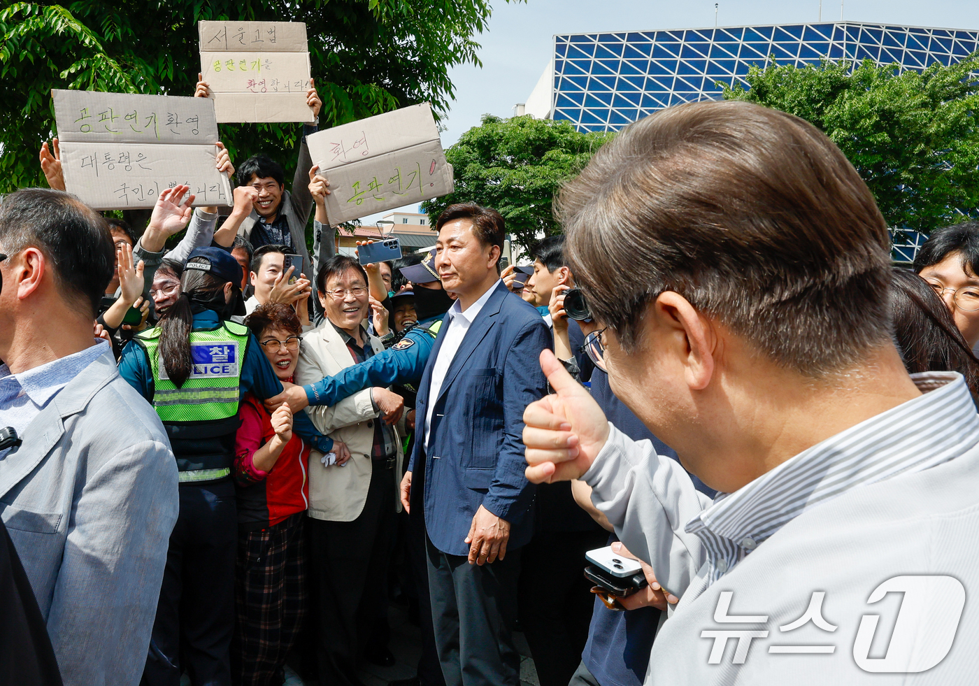 (전주=뉴스1) 안은나 기자 = 이재명 더불어민주당 대통령 후보가 2차 골목골목 경청투어 마지막 날인 7일 오후 전북 전주시 풍남문 앞에서 '공판연기 환영' 종이를 든 지지자들에게 …