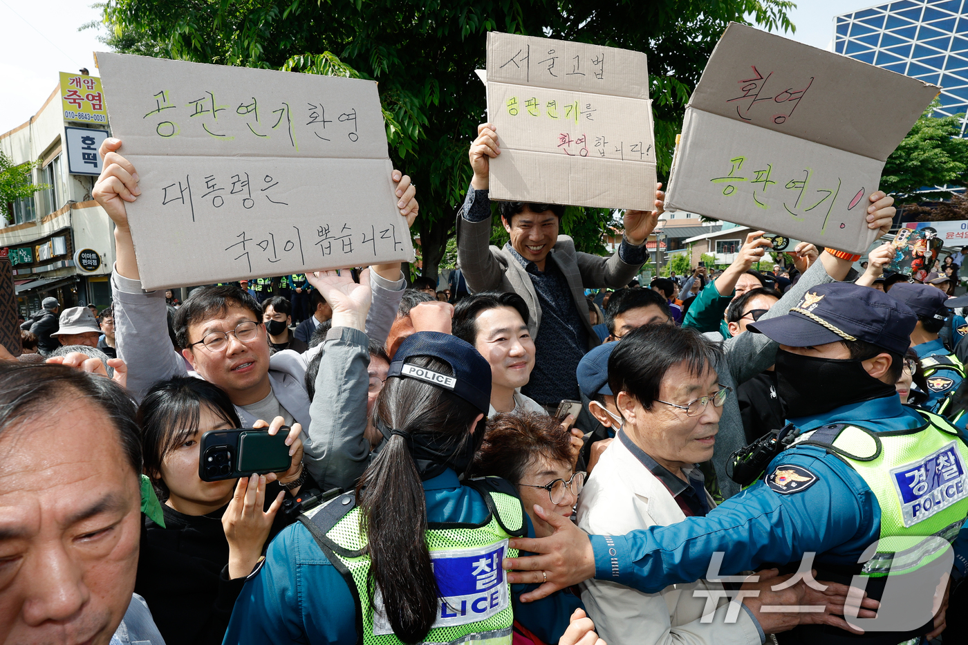 (전주=뉴스1) 안은나 기자 = 이재명 더불어민주당 대통령 후보가 2차 골목골목 경청투어 마지막 날인 7일 오후 전북 전주시 풍남문 앞을 방문하자 지지자들이 '공판연기 환영' 종이 …