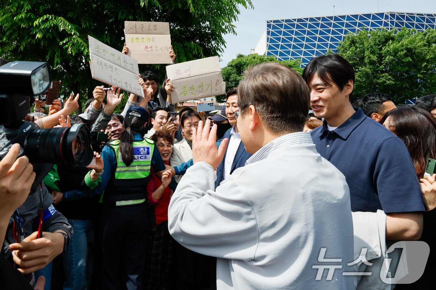 (전주=뉴스1) 안은나 기자 = 이재명 더불어민주당 대통령 후보가 2차 골목골목 경청투어 마지막 날인 7일 오후 전북 전주시 풍남문 앞에서 '공판연기 환영' 종이를 든 지지자들에게 …