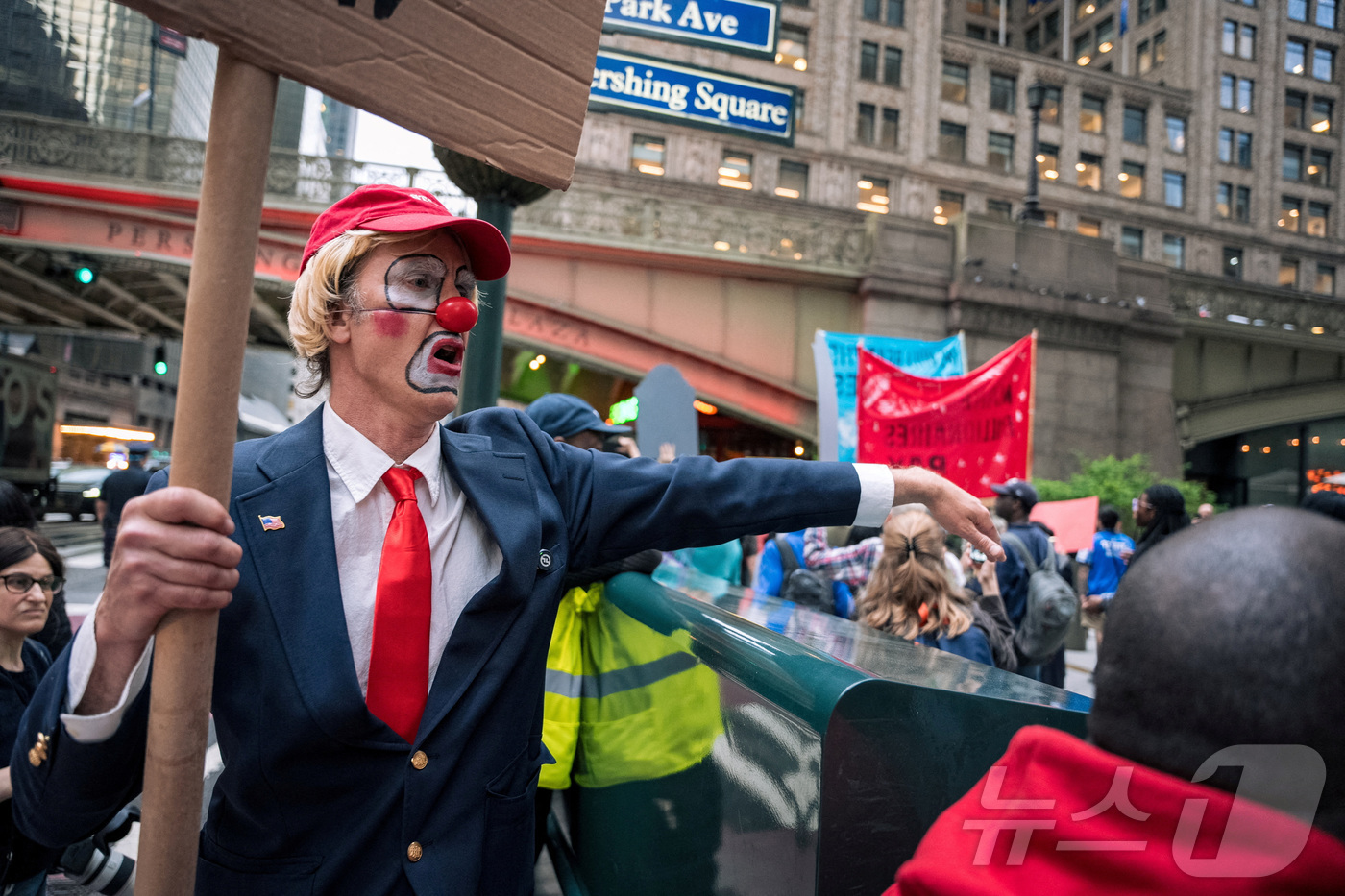 (로이터=뉴스1) 신기림 기자 = 도널드 트럼프 미국 대통령 분장을 하고 빨간 모자를 쓴 한 남성이 7일 뉴욕 맨해튼 미드타운에서 트럼프 행정부와 억만장자 계층에 반대하는 시위에서 …