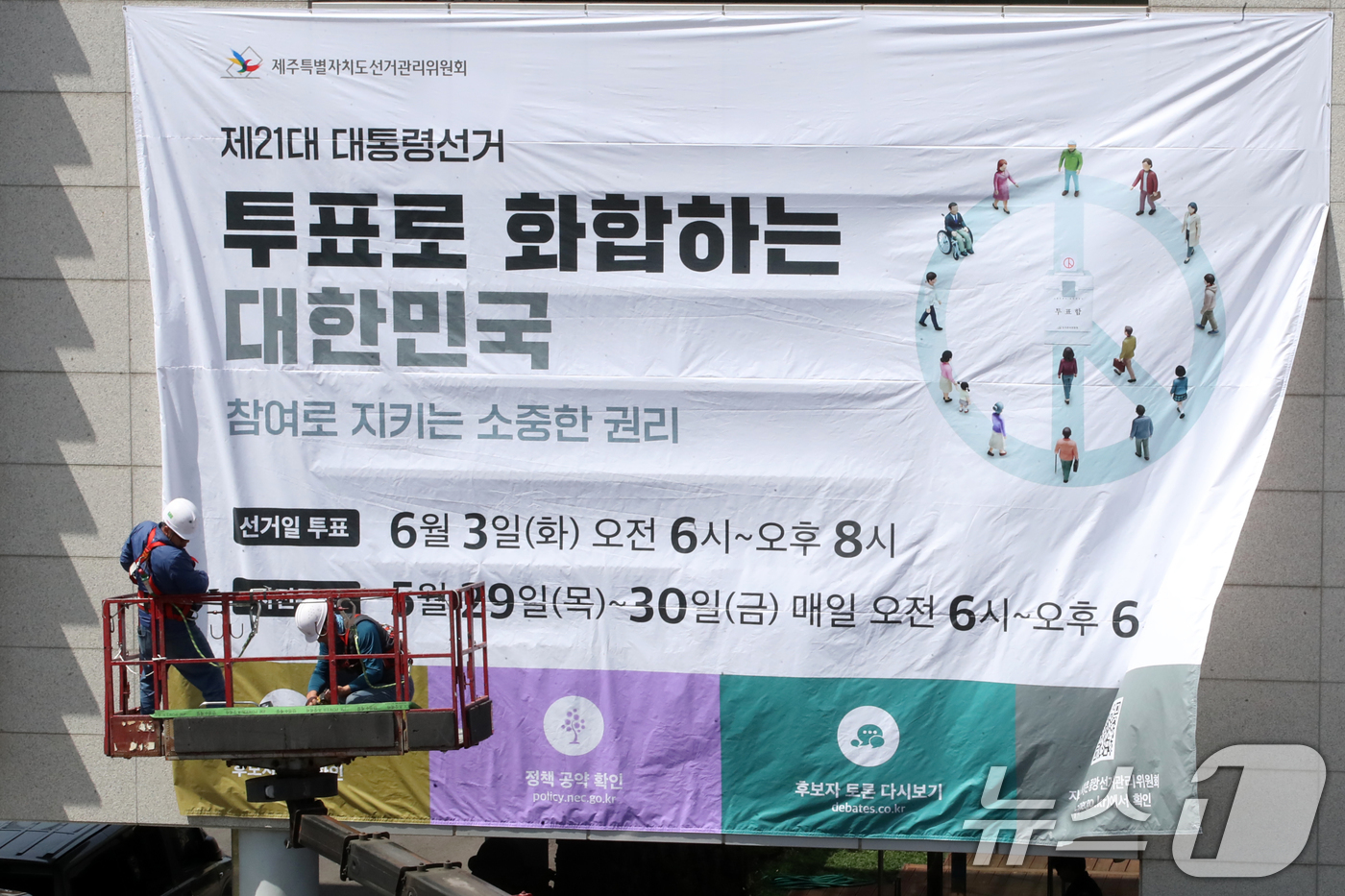 (제주=뉴스1) 오현지 기자 = 8일 오전 제주선거관리위원회에서 관계자들이 청사 외벽에 제21대 대통령선거 투표참여 홍보를 위한 대형 현수막을 게시하고 있다. 2025.5.8/뉴스 …