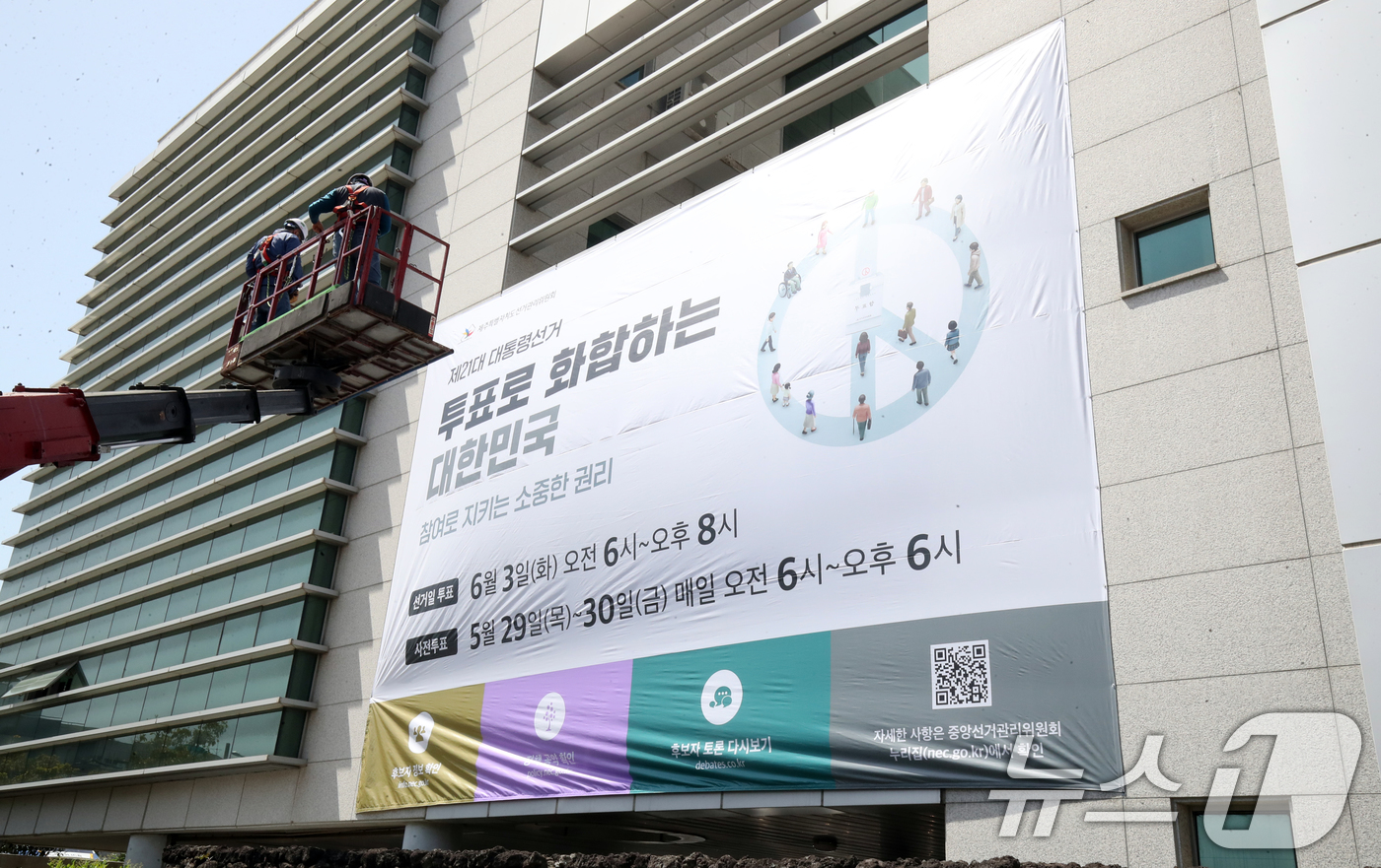 (제주=뉴스1) 오현지 기자 = 8일 오전 제주선거관리위원회에서 관계자들이 청사 외벽에 제21대 대통령선거 투표참여 홍보를 위한 대형 현수막을 게시하고 있다. 2025.5.8/뉴스 …