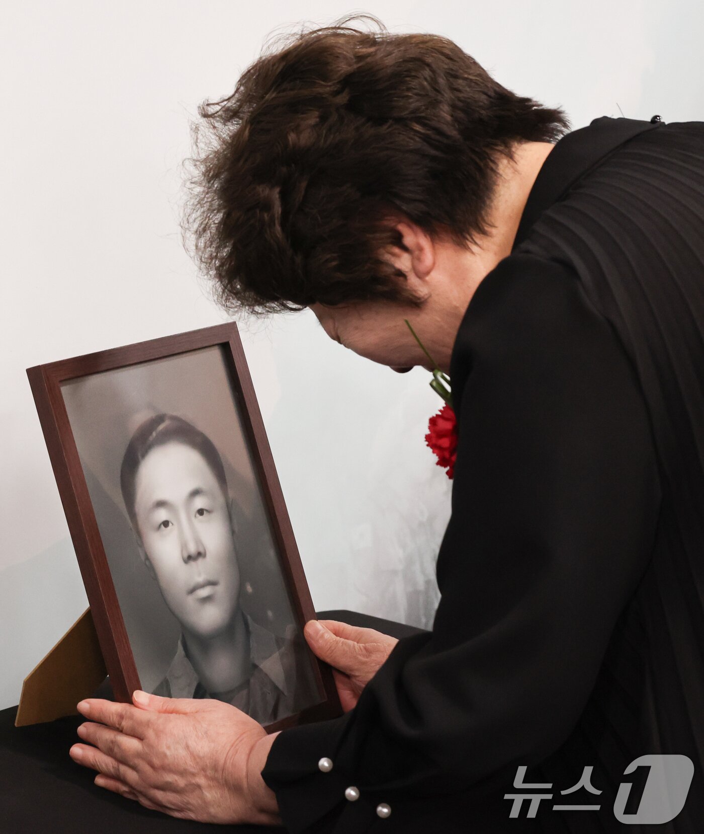 본문 이미지 - 8일 서울 동작구 국방부유해발굴감식단에서 열린 6·25전사자 유해 얼굴복원 유가족 초청행사에서 故 송영환 일병의 딸인 송재숙 씨가 영정을 어루만지고 있다.  2025.5.8/뉴스1 ⓒ News1 허경 기자