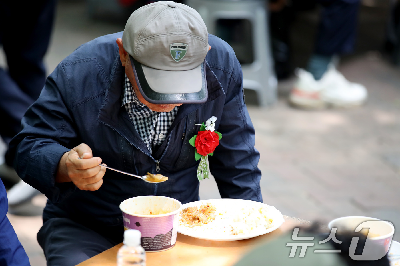 (대구=뉴스1) 공정식 기자 = 어버이날인 8일 오후 대구 달서구 두류공원 사랑해밥차 무료급식소에서 한 어르신이 카네이션을 가슴에 달고 점심을 먹고 있다.무료급식소 측은 이날 어버 …