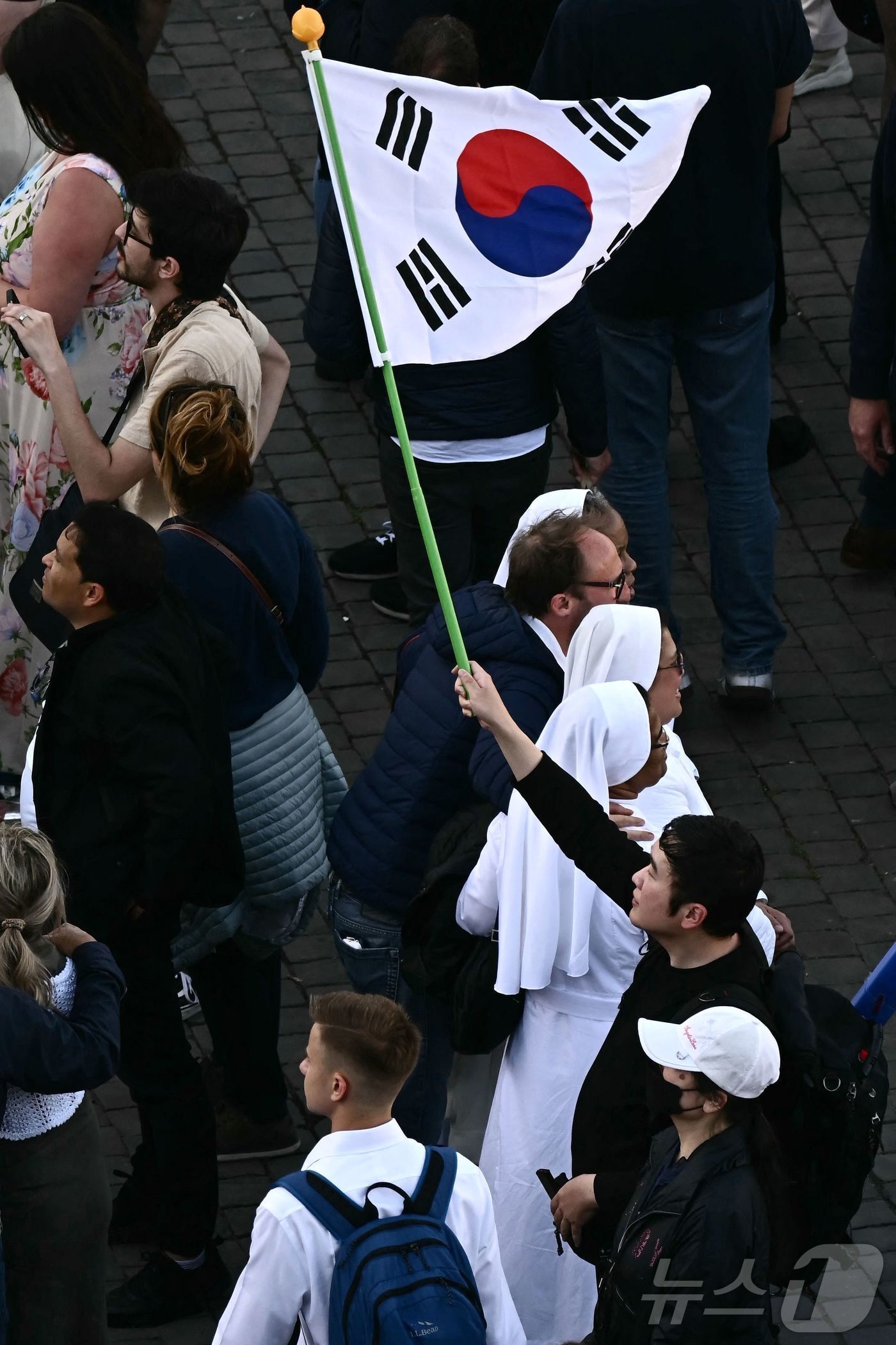 본문 이미지 - 8일(현지시간) 바티칸 성 베드로 광장에서 한국인으로 보이는 한 남성이 태극기를 들고 신임 교황이 성당 발코니에 모습을 드러내길 기다리고 있다. 2025.05.08. ⓒ AFP=뉴스1 ⓒ News1 이지예 객원기자