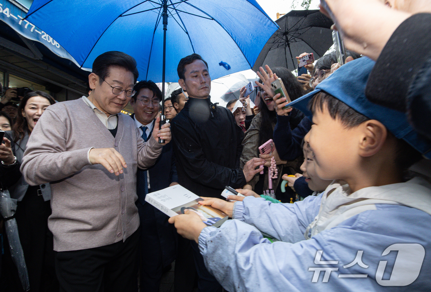(경주=뉴스1) 이재명 기자 = 3차 경청투어에 나선 이재명 더불어민주당 대통령 후보가 9일 오전 경북 경주시 한 아파트 단지를 찾아 어린이들의 사인 요청을 받고 있다. 2025. …