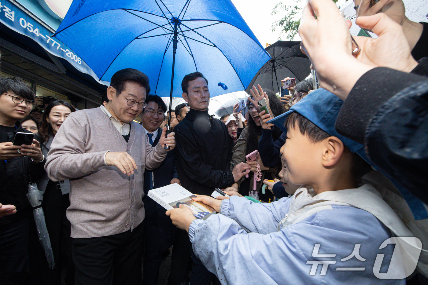 (경주=뉴스1) 이재명 기자 = 3차 경청투어에 나선 이재명 더불어민주당 대통령 후보가 9일 오전 경북 경주시 한 아파트 단지를 찾아 어린이들의 사인 요청을 받고 있다. 2025. …