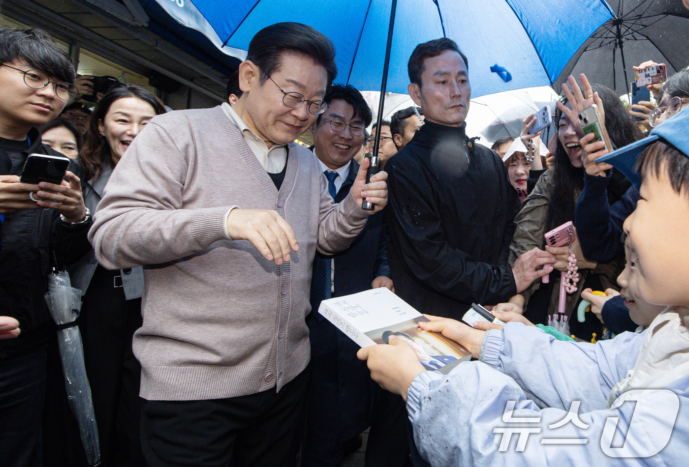 (경주=뉴스1) 이재명 기자 = 3차 경청투어에 나선 이재명 더불어민주당 대통령 후보가 9일 오전 경북 경주시 한 아파트 단지를 찾아 어린이들의 사인 요청을 받고 있다. 2025. …