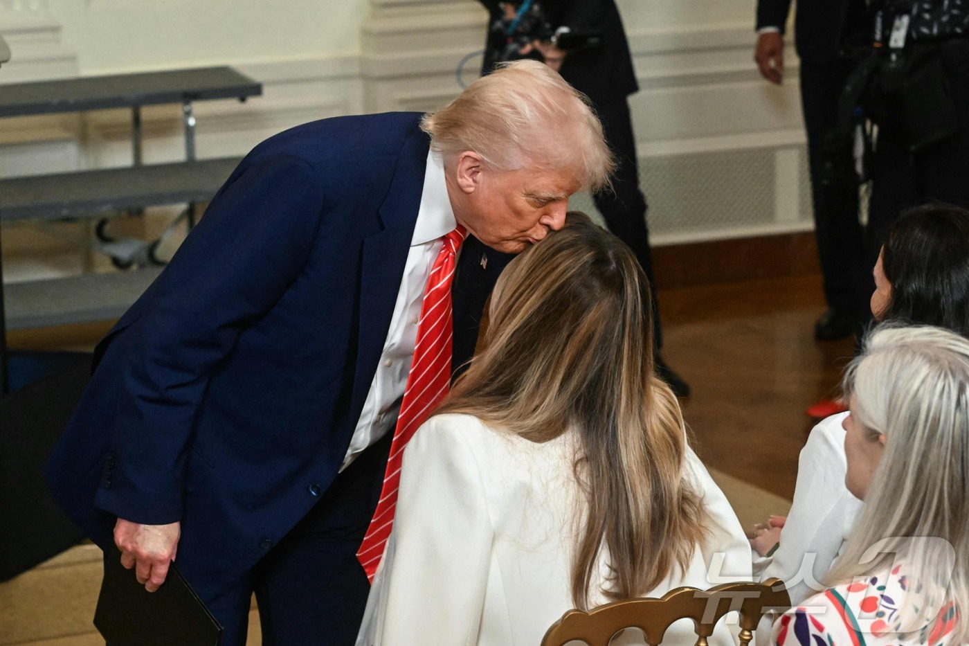 (워싱턴 AFP=뉴스1) 우동명 기자 = 도널드 트럼프 미국 대통령과 부인 멜라니아 여사가 8일(현지시간) 워싱턴 백악관에서 열린 군인 어머니 초청 행사서 키스를 하고 있다. 20 …