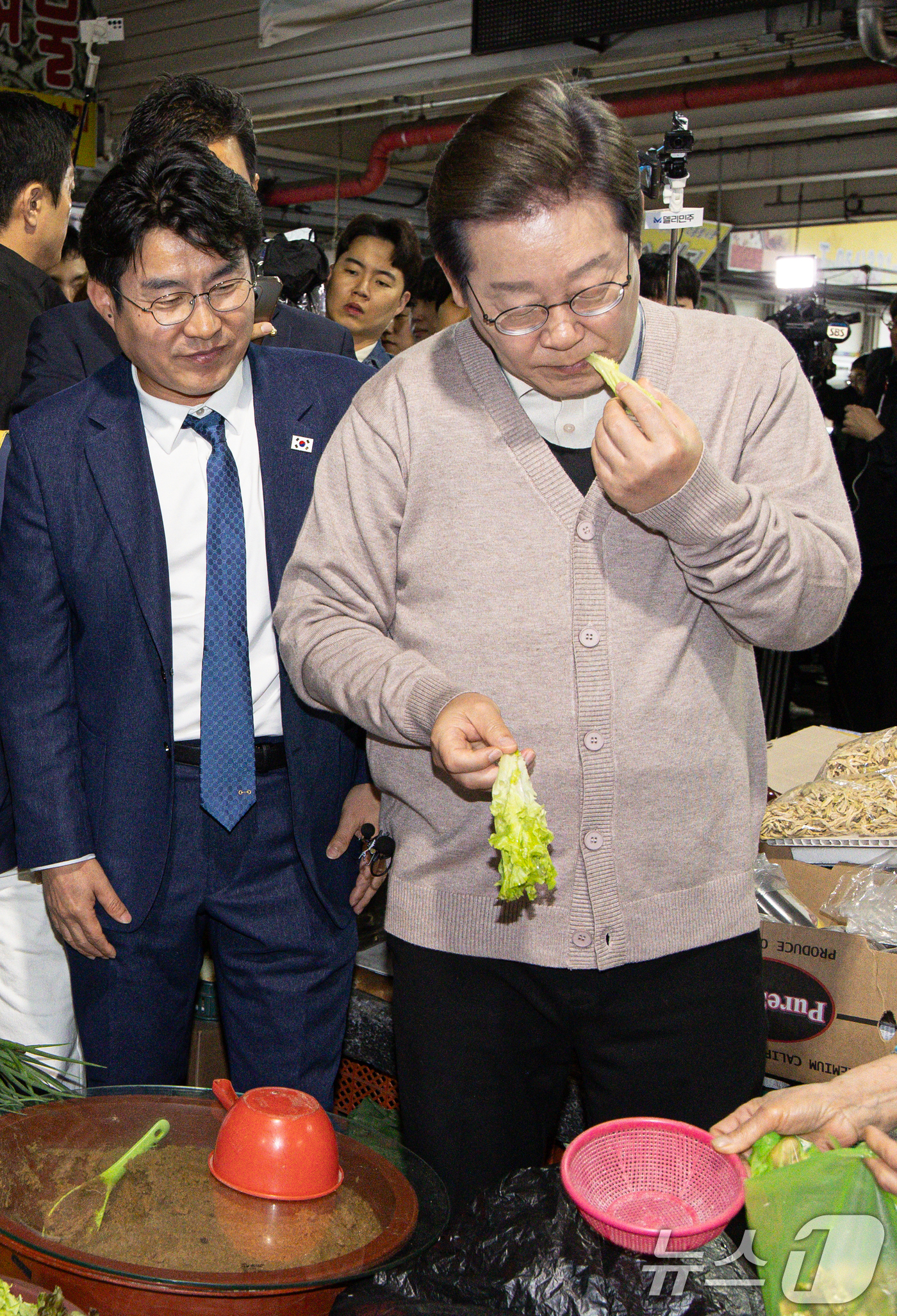 (영천=뉴스1) 이재명 기자 = 3차 경청투어에 나선 이재명 더불어민주당 대통령 후보가 9일 오전 경북 영천시완산동 영천공설시장에서 상추를 맛보고 있다. 2025.5.9/뉴스1