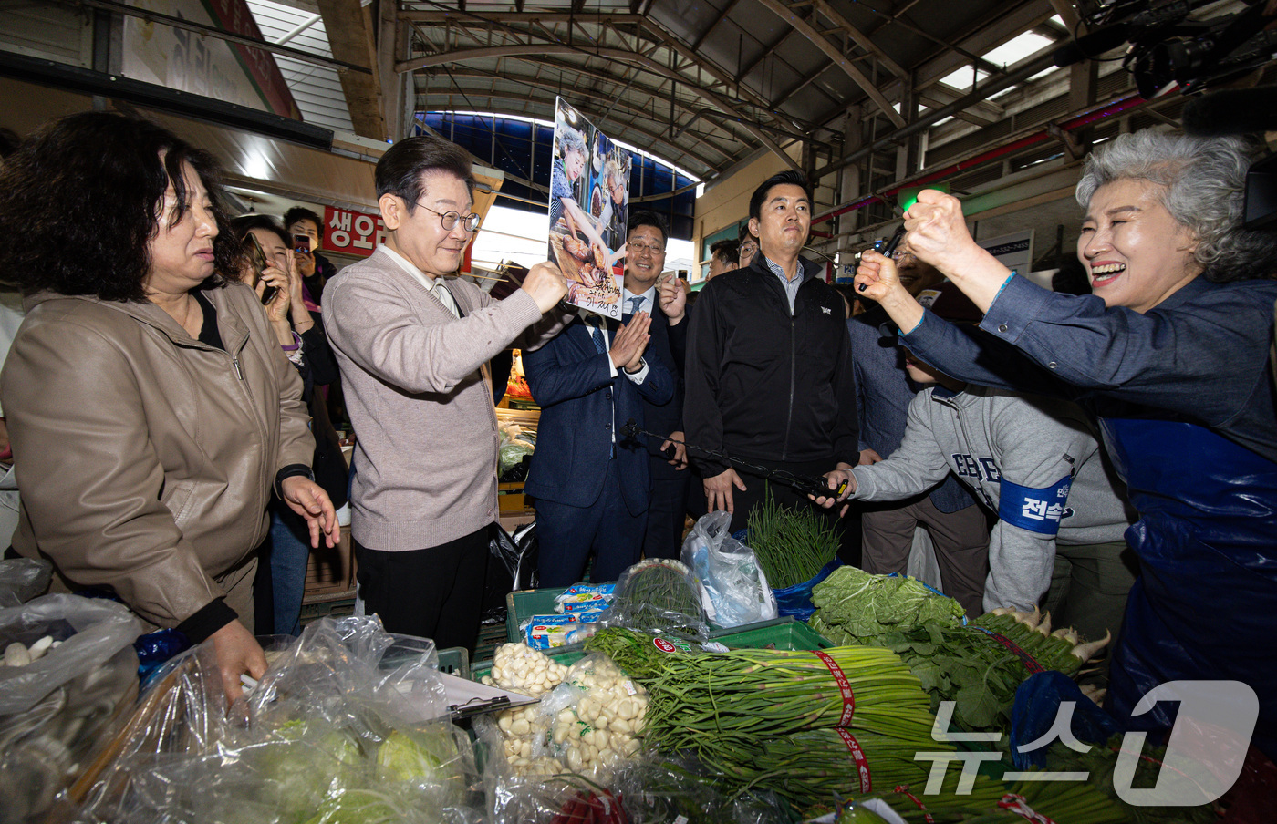 (영천=뉴스1) 이재명 기자 = 3차 경청투어에 나선 이재명 더불어민주당 대통령 후보가 9일 오전 경북 영천시완산동 영천공설시장에서 한 상인 요청으로 사인한 후 들어보이고 있다. …