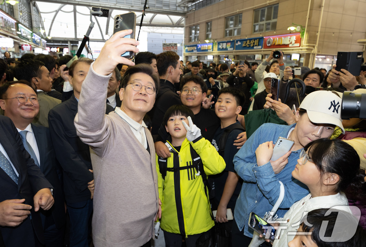 (성주=뉴스1) 이재명 기자 = 3차 경청투어에 나선 이재명 더불어민주당 대통령 후보가 9일 오후 경북 성주군 성주전통시장에서 어린이들과 기념촬영을 하고 있다. 2025.5.9/뉴 …
