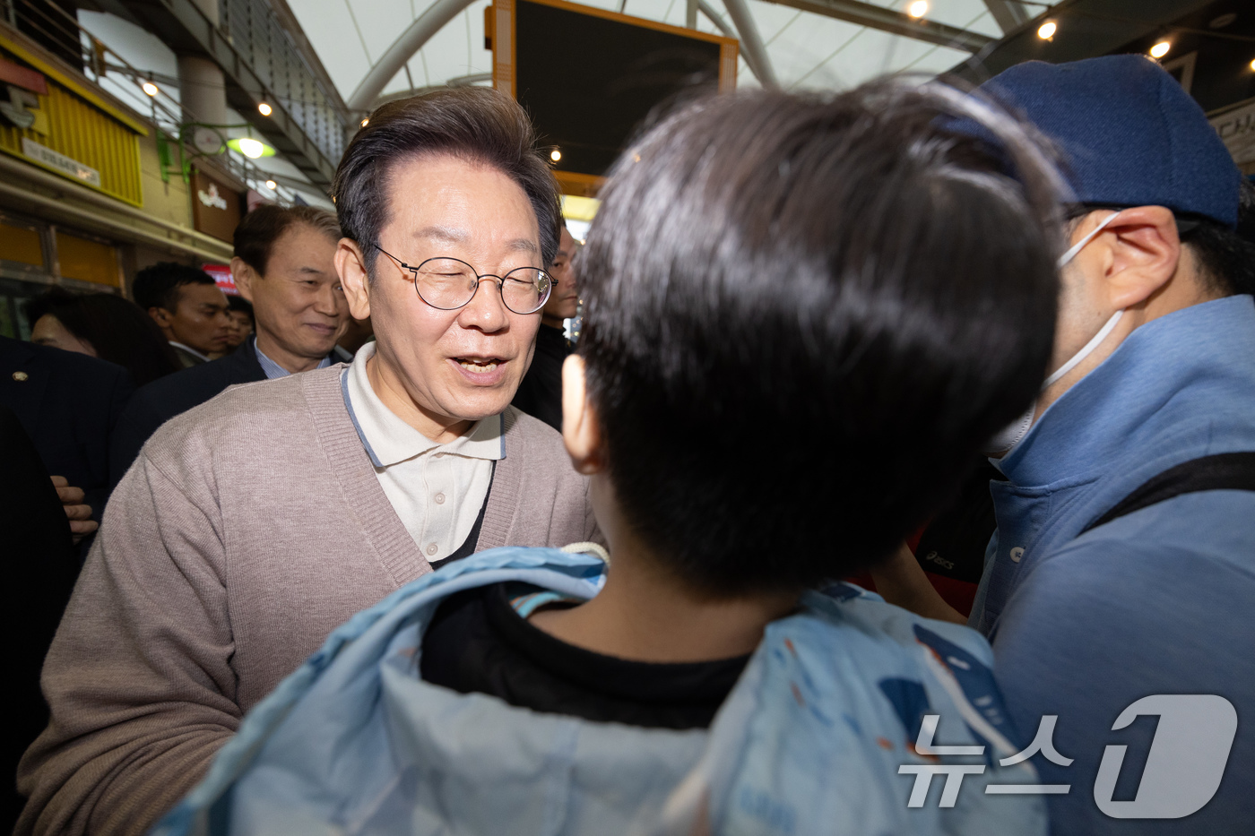 (성주=뉴스1) 이재명 기자 = 3차 경청투어에 나선 이재명 더불어민주당 대통령 후보가 9일 오후 경북 성주군 성주전통시장에서 한 어린이를 안고 있다. 2025.5.9/뉴스1