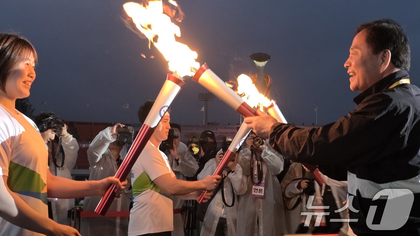 (김천=뉴스1) 정우용 기자 = 9일 오후 경북 김천종합운동장에서 열린 제63회 경북도민체전 개회식에서 배낙호 김천시장(오른쪽 첫번째)이 최종 주자에게 성화를 전달하고 있다. 20 …