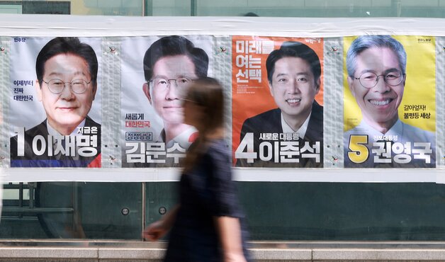 본문 이미지 - 21대 대통령 선거가 하루 앞으로 다가온 가운데 한 시민이 선거 벽보 앞으로 지나고 있다.(자료사진)/뉴스1