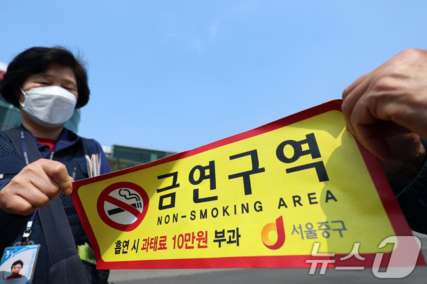 본문 이미지 - 1일 오전 서울역광장에서 중구청 관계자들이 '금연구역' 안내 스티커를 붙이고 있다. ⓒ 뉴스1 황기선 기자