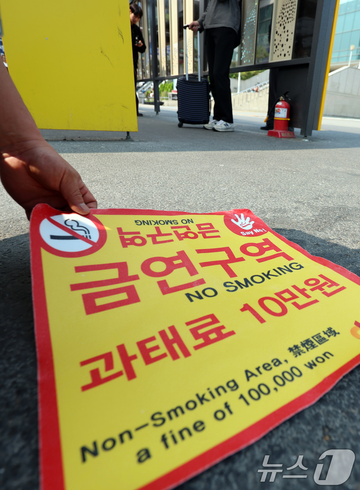 (서울=뉴스1) 황기선 기자 = 1일 오전 서울역광장에서 중구청 관계자들이 '금연구역' 안내 스티커를 붙이고 있다.이날부터 서울역광장과 인근 도로 약 5만 7천㎡가 금연구역으로 지 …