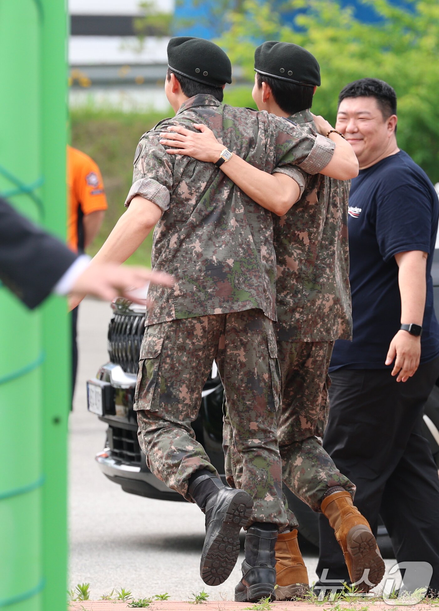 본문 이미지 - 방탄소년단&#40;BTS&#41;의 RM&#40;김남준, 30&#41;과 뷔&#40;김태형, 29&#41;가 10일 오전 강원도 춘천시 신북읍 체육공원 축구장에서 전역 인사를 마친 뒤 어깨 동무를 하고 준비된 차량으로 이동하고 있다. ⓒ News1 권현진 기자