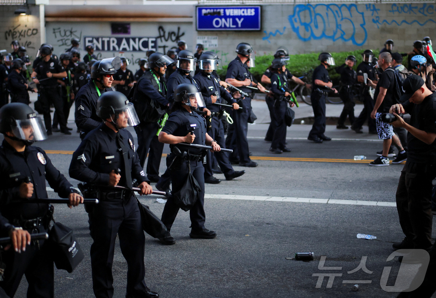 (LA 로이터=뉴스1) 권영미 기자 = 9일(현지시간) 미국 로스앤젤레스(LA) 경찰들이 곤봉을 쥔 채 시위대를 진압하러 나아가고 있다. 2025.06.09.ⓒ 로이터=뉴스1