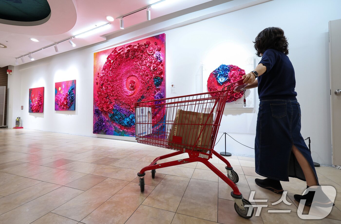 본문 이미지 - 10일 롯데마트 송파점 mART 센터에서 열린 &#39;2025 더 고가 서울국제아트페어 페스티벌&#39;에서 시민들이 로즈박 작가의 &#39;한지 아프리카를 품다&#40;불멸과 사랑&#41;&#39; 작품 내 탄자나이트를 보고 있다. 2025.6.10/뉴스1 ⓒ News1 김성진 기자