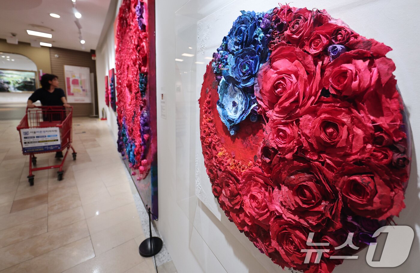 본문 이미지 - 10일 롯데마트 송파점 mART 센터에서 열린 &#39;2025 더 고가 서울국제아트페어 페스티벌&#39;에서 시민들이 로즈박 작가의 &#39;한지 아프리카를 품다&#40;불멸과 사랑&#41;&#39; 작품 내 탄자나이트를 보고 있다. 2025.6.10/뉴스1 ⓒ News1 김성진 기자