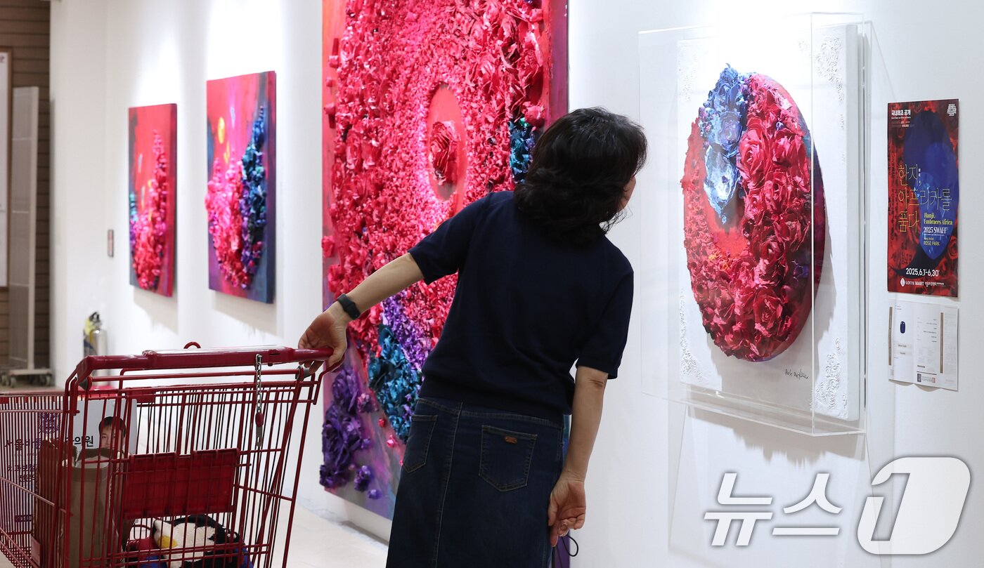 본문 이미지 - 10일 롯데마트 송파점 mART 센터에서 열린 &#39;2025 더 고가 서울국제아트페어 페스티벌&#39;에서 시민들이 로즈박 작가의 &#39;한지 아프리카를 품다&#40;불멸과 사랑&#41;&#39; 작품 내 탄자나이트를 보고 있다. 2025.6.10/뉴스1 ⓒ News1 김성진 기자