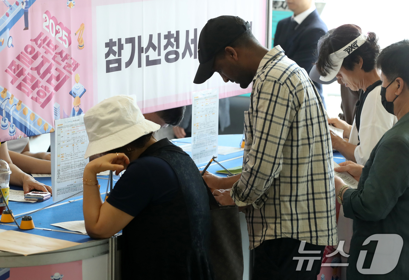(부산=뉴스1) 윤일지 기자 = 10일 오후 부산 강서구 강서구청역 대합실에서 열린 '2025년 서부산권 일자리박람회'에서 구직자들이 참가 신청서를 작성하고 있다.부산 강서구, 북 …