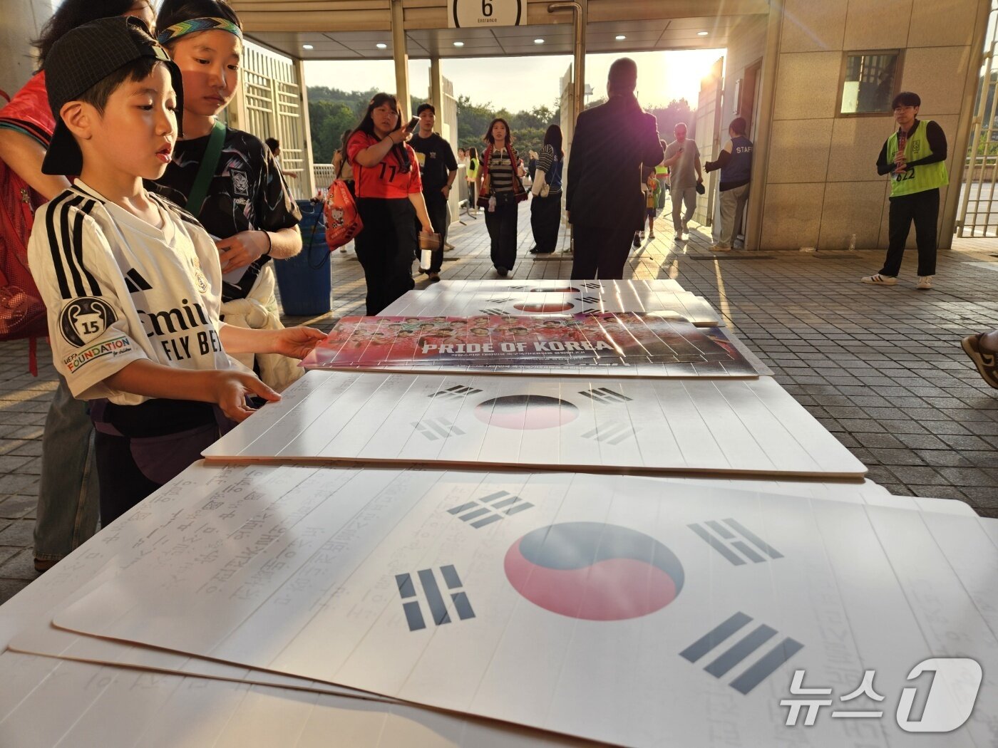 본문 이미지 - 한국-쿠웨이트전에 입장하는 팬들이 태극기 클래퍼를 받아들고 있다. ⓒ News1 안영준 기자