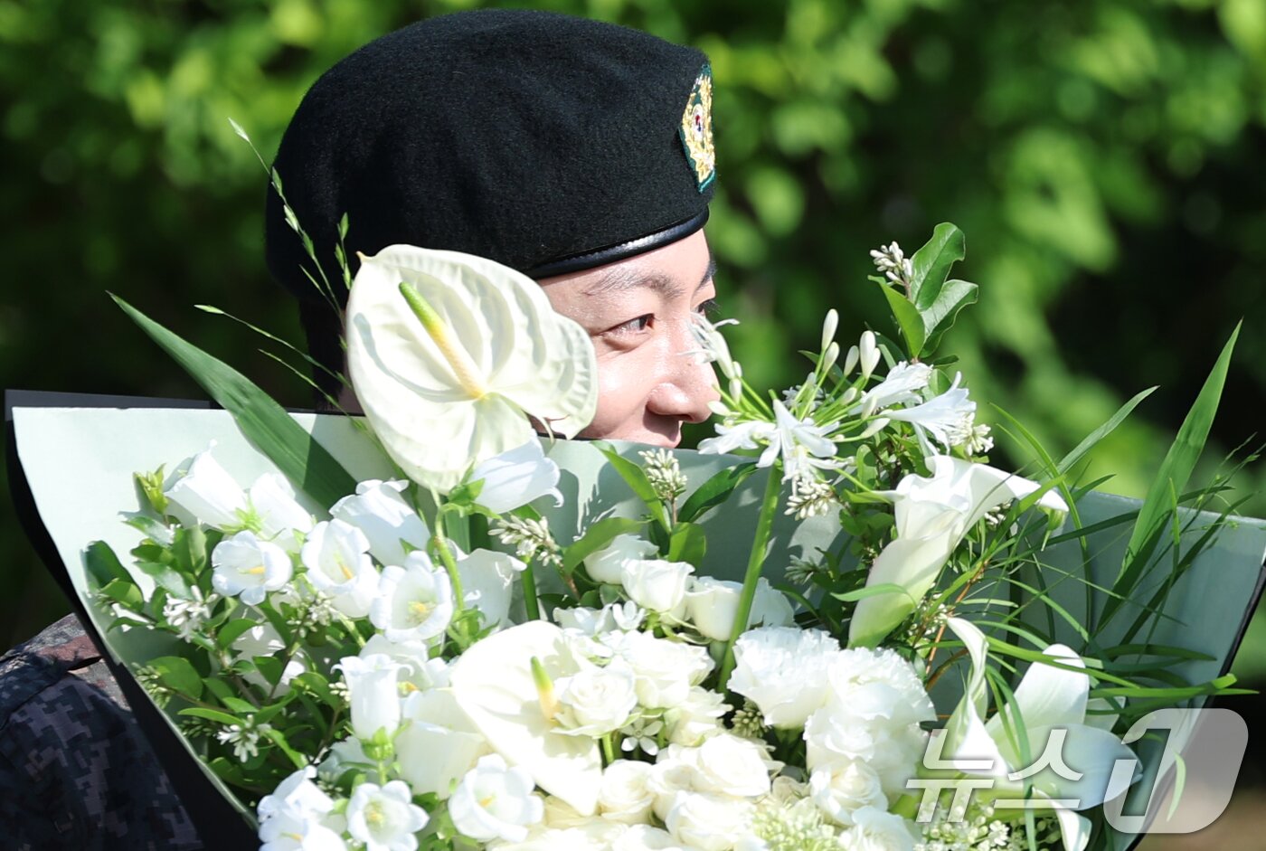본문 이미지 - 방탄소년단&#40;BTS&#41;의 정국이 11일 오전 경기도 연천군 연천공설운동장에서 군복무를 마친 뒤 꽃다발을 받고 수줍은 미소를 짓고 있다.  ⓒ News1 권현진 기자