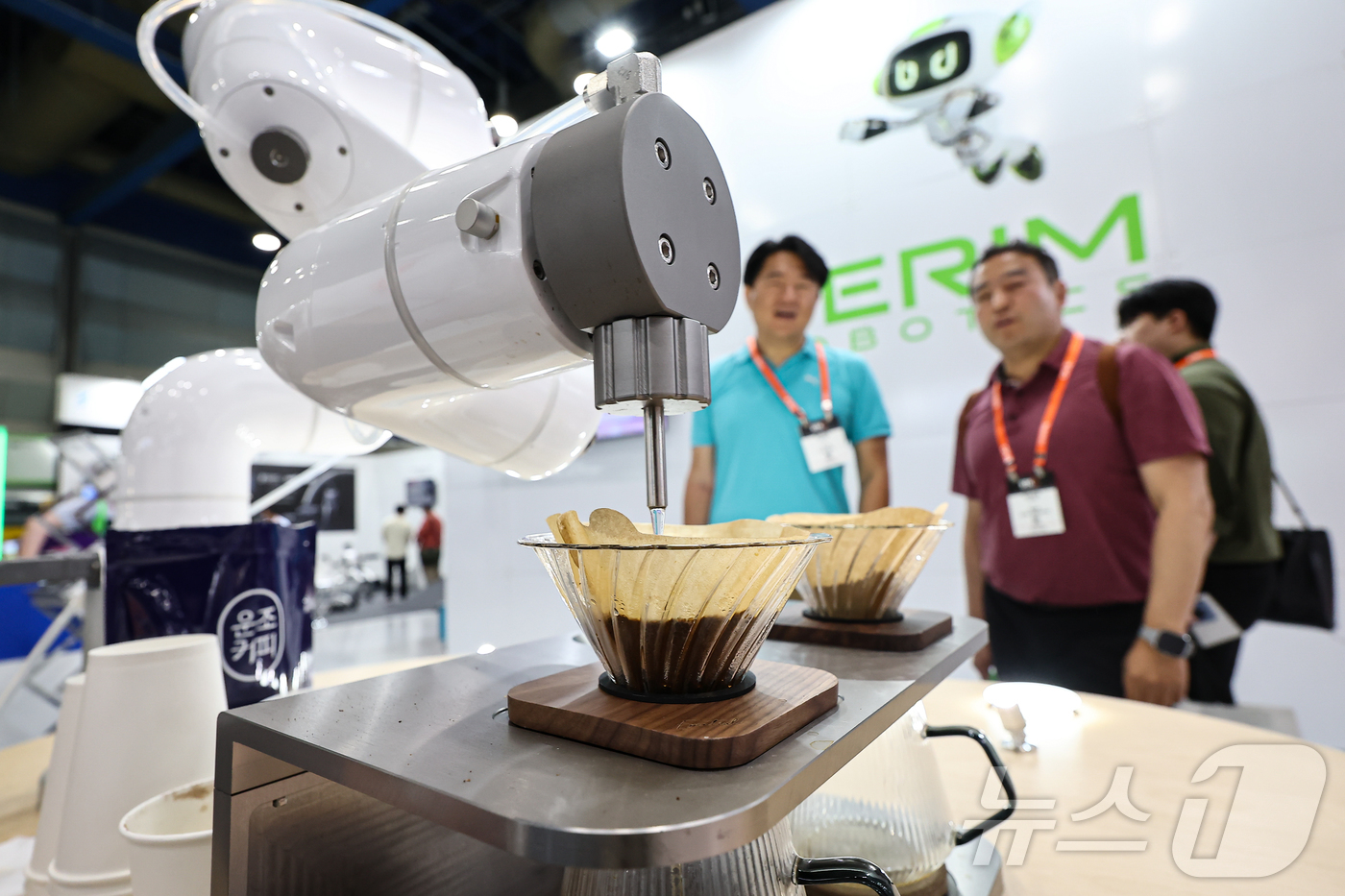 (서울=뉴스1) 김도우 기자 = 11일 서울 강남구 코엑스에서 열린 '2025 스마트테크 코리아'에서 관람객들이 로봇이 만드는 커피를 살펴보고 있다.올해로 14회째 맞는 이번 전시 …