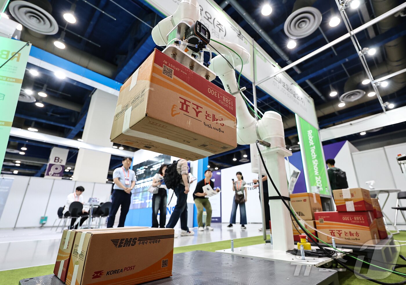 본문 이미지 - 11일 서울 강남구 코엑스에서 열린 &#39;2025 스마트테크 코리아&#39;에서 관람객들이 로봇을 활용한 물류시스템을 살펴보고 있다. 2025.6.11/뉴스1 ⓒ News1 김도우 기자