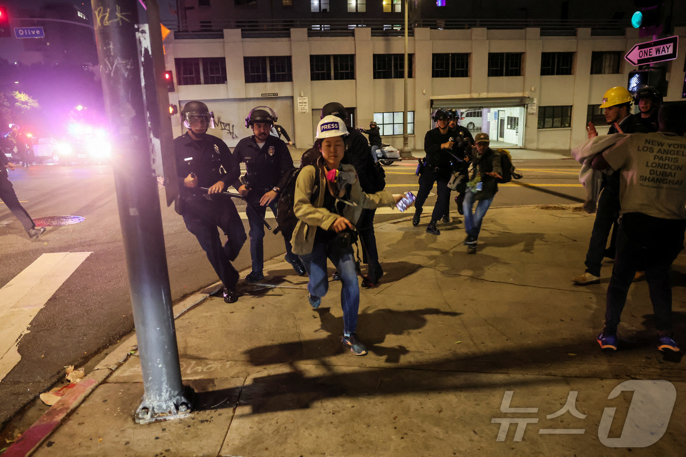 (LA 로이터=뉴스1) 김경민 기자 = 미국 캘리포니아주 로스앤젤레스(LA) 시내에서 이민 단속에 항의하는 시위가 계속되고 있는 가운데, 한 언론인이 통금 시간 이후 작전을 수행하 …