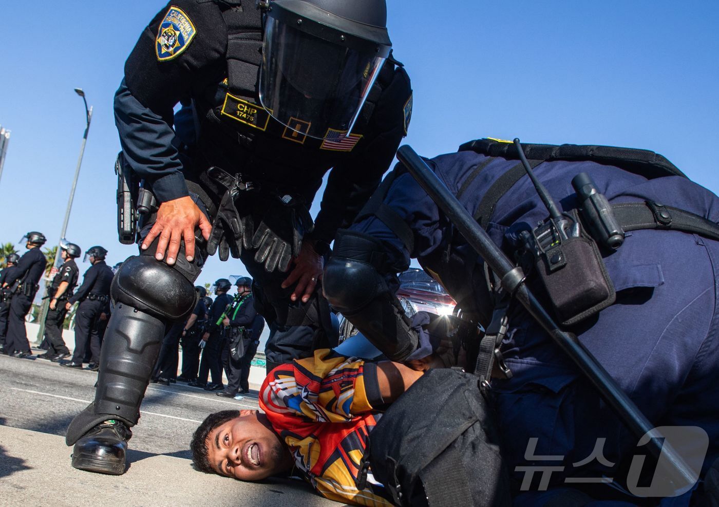 본문 이미지 - 6월 10일 미국 캘리포니아 로스앤젤레스&#40;LA&#41;에서 연방 당국의 이민 단속 조치에 항의하는 시위가 계속되고 있는 가운데 캘리포니아 고속도로 순찰대원이 101 프리웨이 고가도로에서 시위 참가자를 체포하고 있다. 2025.06.10 ⓒ AFP=뉴스1 ⓒ News1 최종일 선임기자