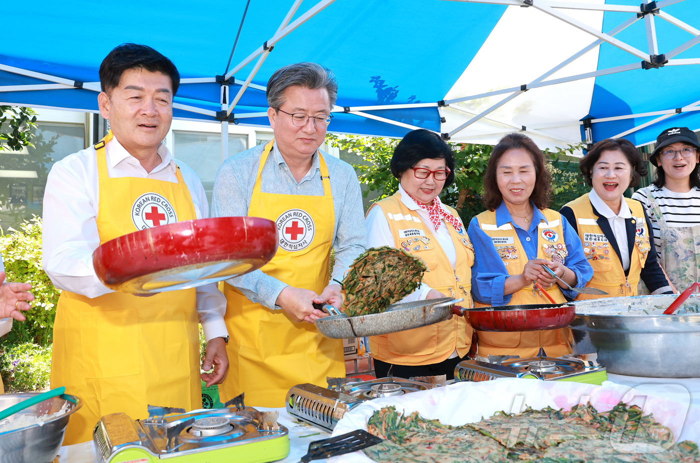 (대전=뉴스1) 이동원 기자 = 정용래 대전 유성구청장(왼쪽 두 번째)이 지난 11일 구암동 유성구 커뮤니티센터에서 열린전통음식 만들기 체험 행사에서 전을 부치고 있다.이번 행사는 …