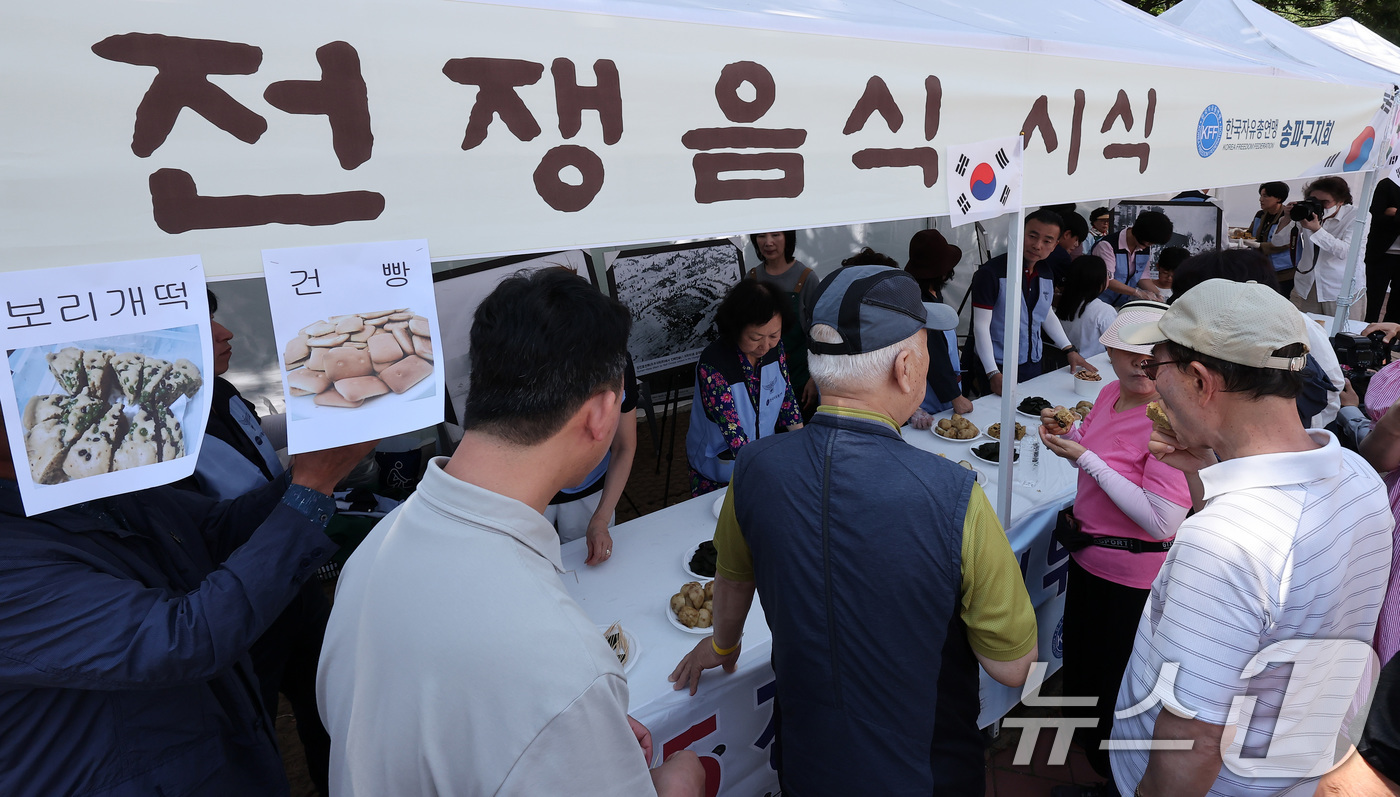 (서울=뉴스1) 김성진 기자 = 12일 서울 송파구 서울놀이마당에서 열린 '송파구 보훈가족 한마당 행사'에서 시민들이 전쟁음식 시식을 하고 있다. 2025.6.12/뉴스1