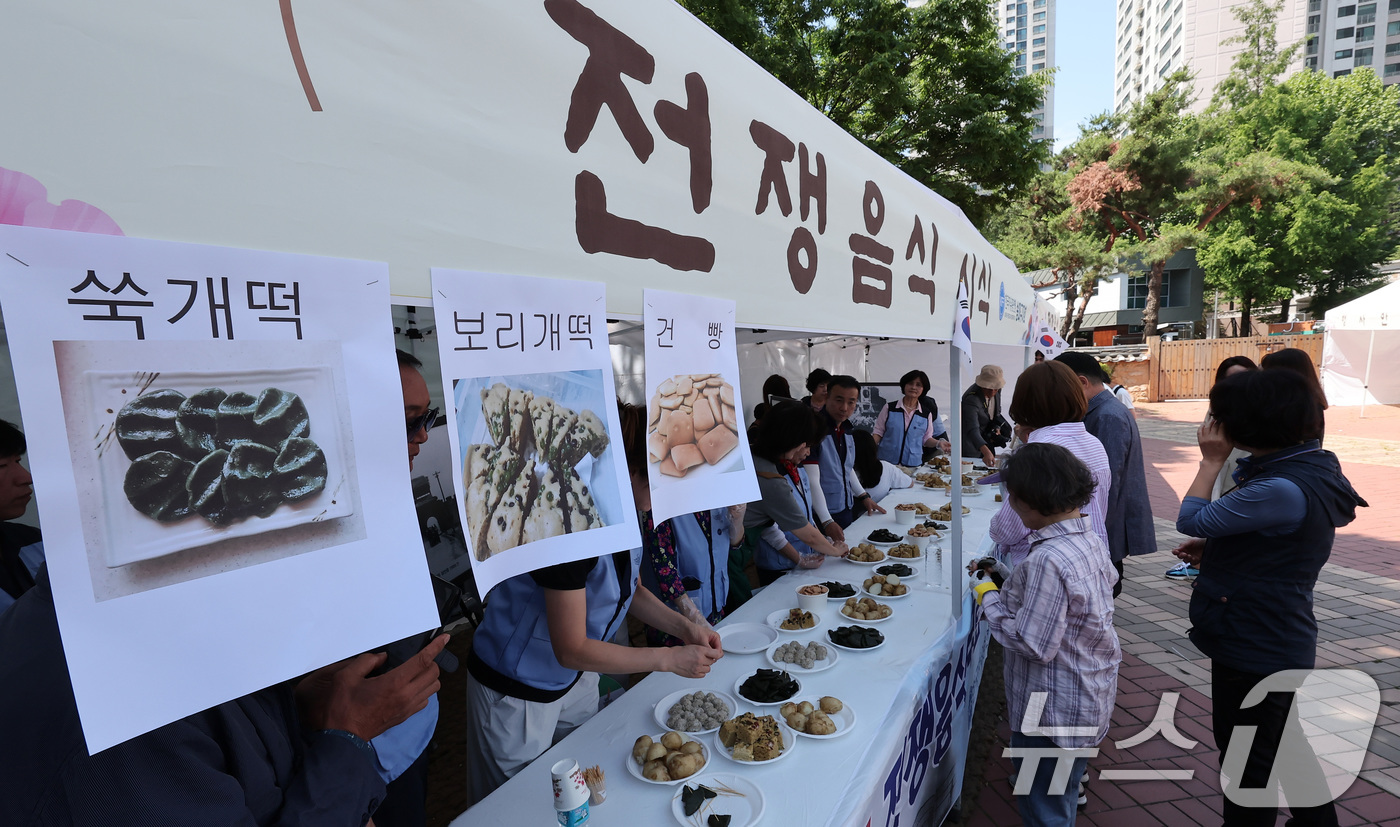 (서울=뉴스1) 김성진 기자 = 12일 서울 송파구 서울놀이마당에서 열린 '송파구 보훈가족 한마당 행사'에서 시민들이 전쟁음식 시식을 하고 있다. 2025.6.12/뉴스1