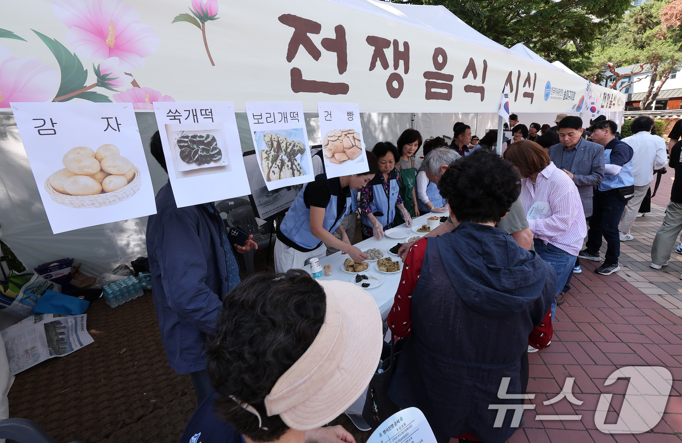 (서울=뉴스1) 김성진 기자 = 12일 서울 송파구 서울놀이마당에서 열린 '송파구 보훈가족 한마당 행사'에서 시민들이 전쟁음식 시식을 하고 있다. 2025.6.12/뉴스1