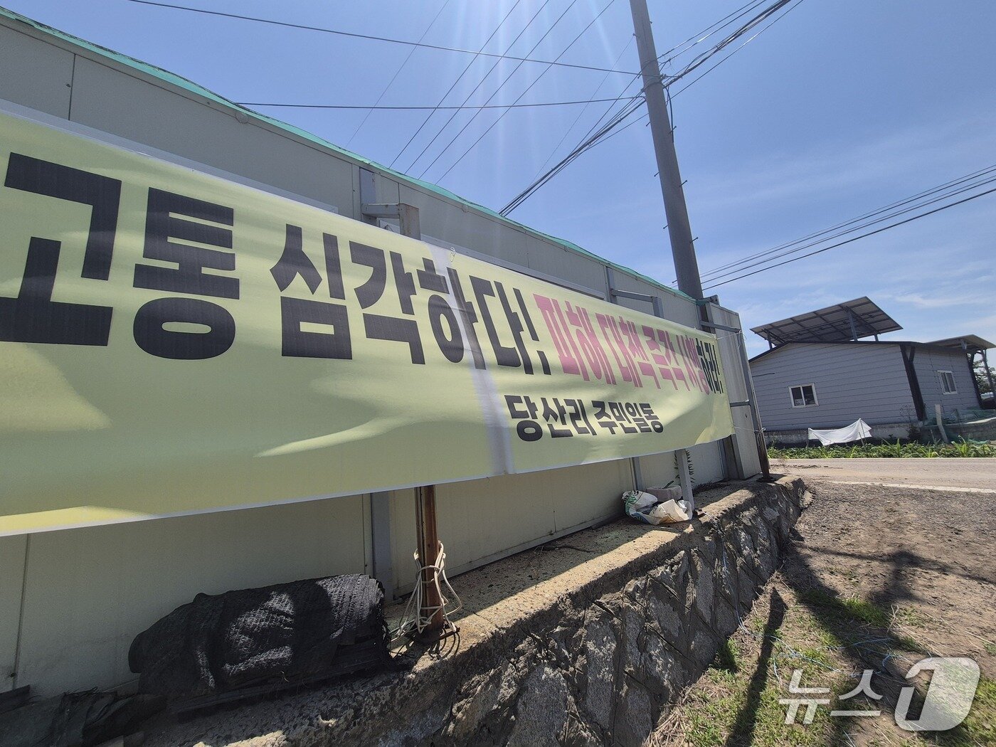 본문 이미지 - 인천 강화군 당산리 마을회관 외벽에 붙어 있는 현수막(이시명 기자/뉴스1)