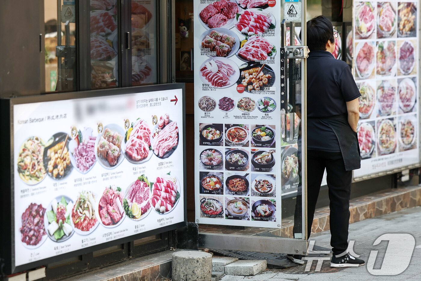 본문 이미지 - 서울 중구 명동의 한 식당에서 한 자영업자가 문 밖에 서서 손님을 기다리고 있다. 2025.6.12/뉴스1 ⓒ News1 민경석 기자