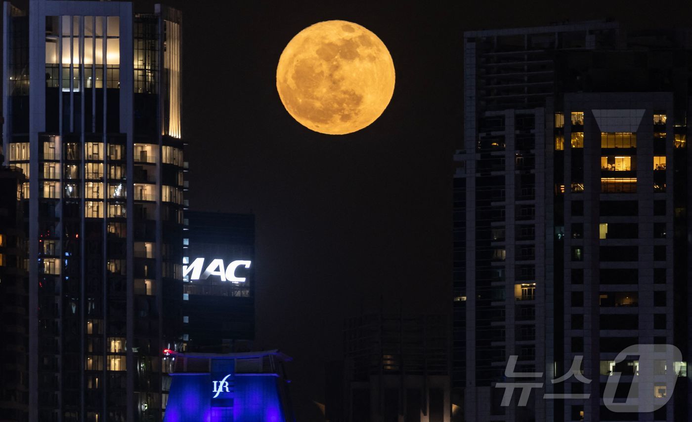 (두바이 AFP=뉴스1) 신기림 기자 = '딸기 달(strawberry moon)'로 알려진 보름달이 2025년 6월 11일 두바이 스카이라인 위로 떠오르고 있다. 6월에 뜨는 보 …
