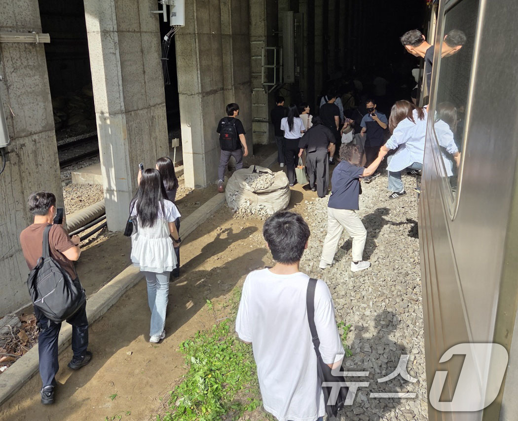 (서울=뉴스1) = 13일 오전 경의중앙선 신촌역 인근에서 서울역행 경의중앙선 열차가 단전으로 인해 신촌역 앞 50m지점에서 멈취 승객들이 열차에서 내려 신촌 역으로 걸어가고 있다 …